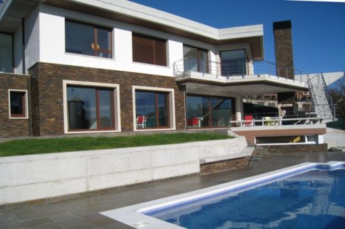 Piscina en vivienda unifamiliar de piedra gris y blanca