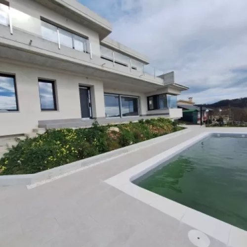 Vista de la Casa en obra con el mar al fondo, mostrando la integración con el entorno.